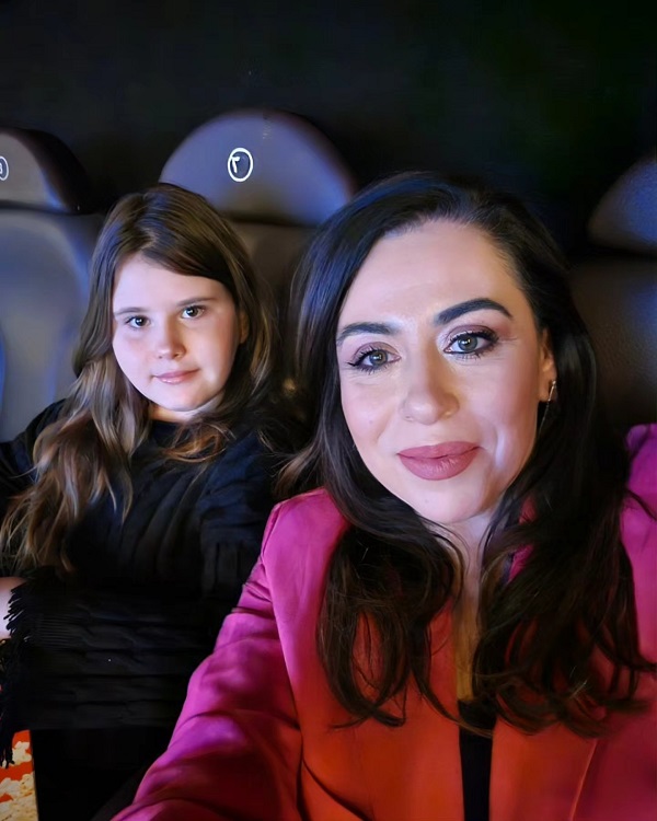 oana roman imbracata in rosu face un selfie alaturi de fiica ei stand pe scaune