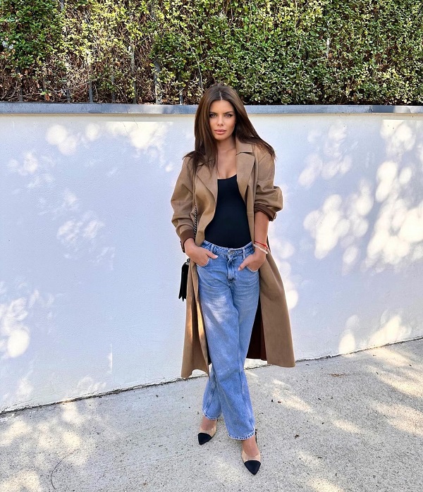 ileana lazariuc imbracata lejer in blugi și un trench maro pozeaza cu mainile in buzunar