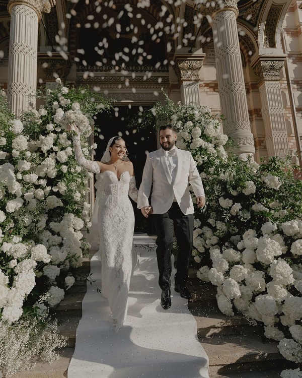 larisa udila in rochie de mireasa ridica buchetul in aer alaturi de sotul ei in costum de mire