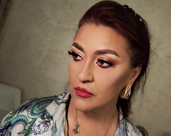 rona hartner machiata si cu parul aranjat se uita intr-o parte