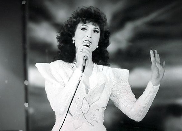 angela similea imbracata in alb pe scena cu microfonul in mana