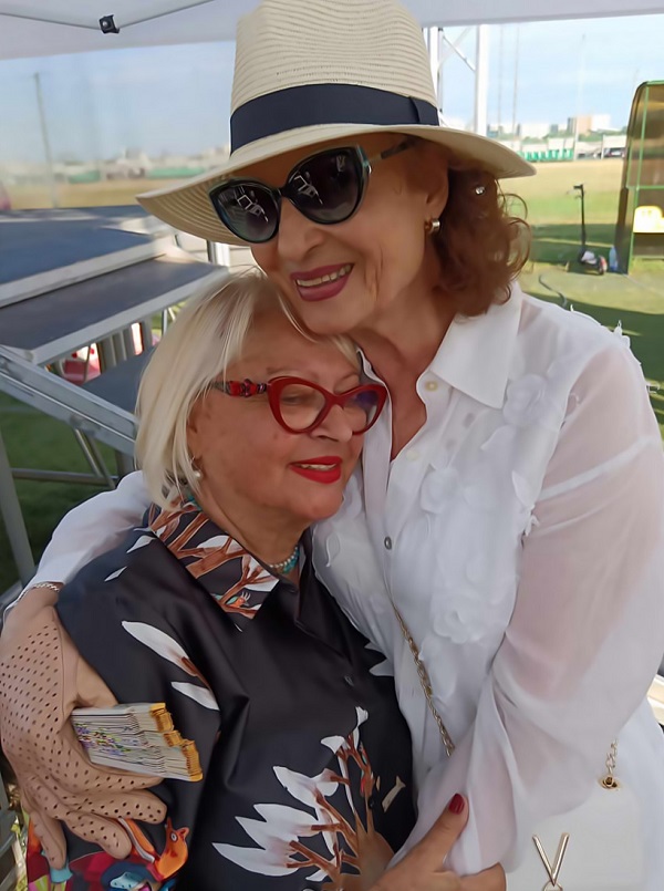 angela similea cu ochelari la ochi si palarie pe cap o imbratiseaza pe mirabela dauer