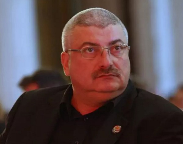silviu prigoana cu ochelari la ochi sta pe scaun la un eveniment imbracat in negru