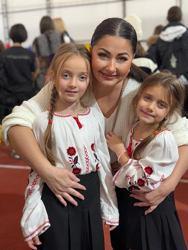 gabriela cristea isi imbratiseaza cele doua fetite care poarta costum popular