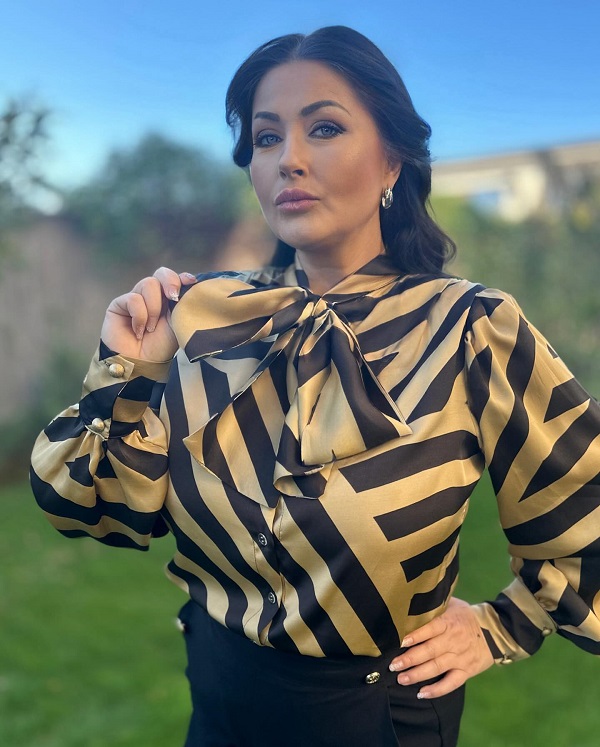 gabriela cristea imbracata in bluza auriu cu negru tine funda de la gat