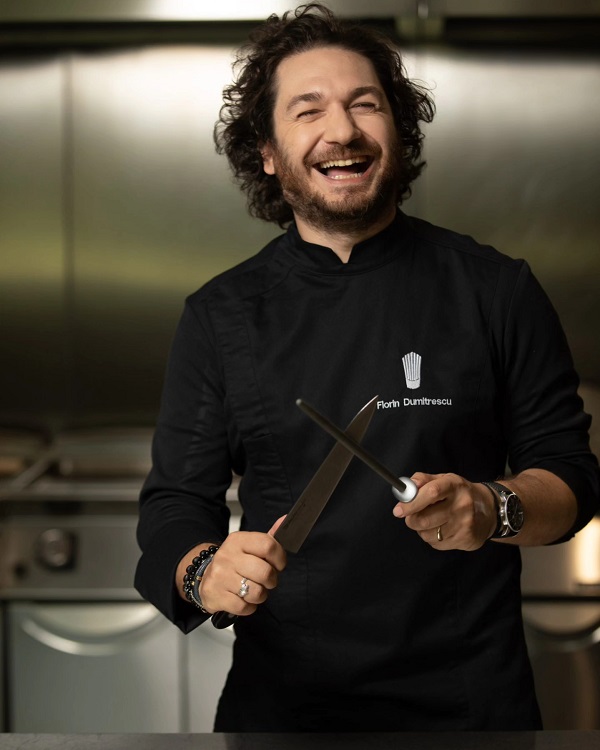 chef florin dumitrescu imbracat in negru zambeste si ascute un cutit