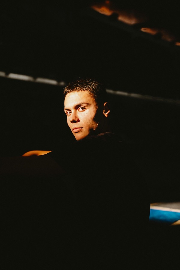 david popovici imbracat in negru in semiumbra se uita in spate