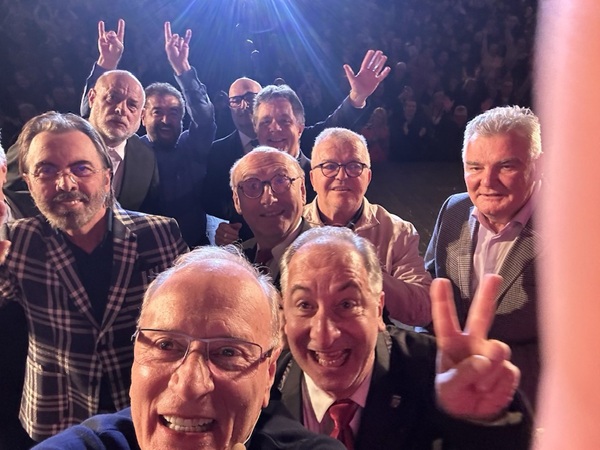 membriii trupei divertis fac un selfie in sala in timp ce rad