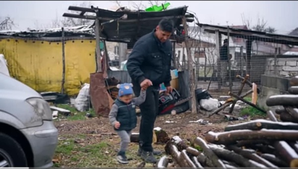 marius moldovan isi tine de mana copilul care urca pe o gramada de lemne