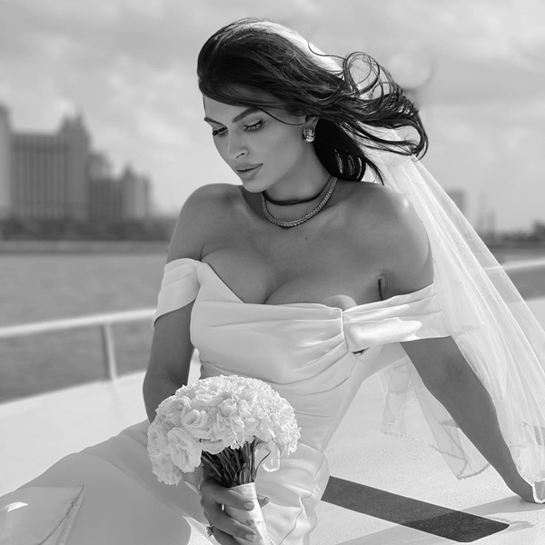 madalina pamfile imbracata in rochie de mireasa pe un yacht cu un buchet de flori in mana
