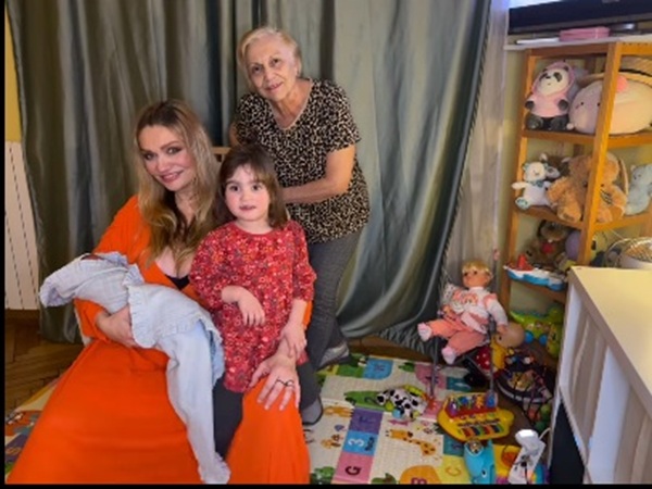 cristina cioran sta pe scaun si isi tine bebelusul in brate inconjurata de mama si de fiica ei