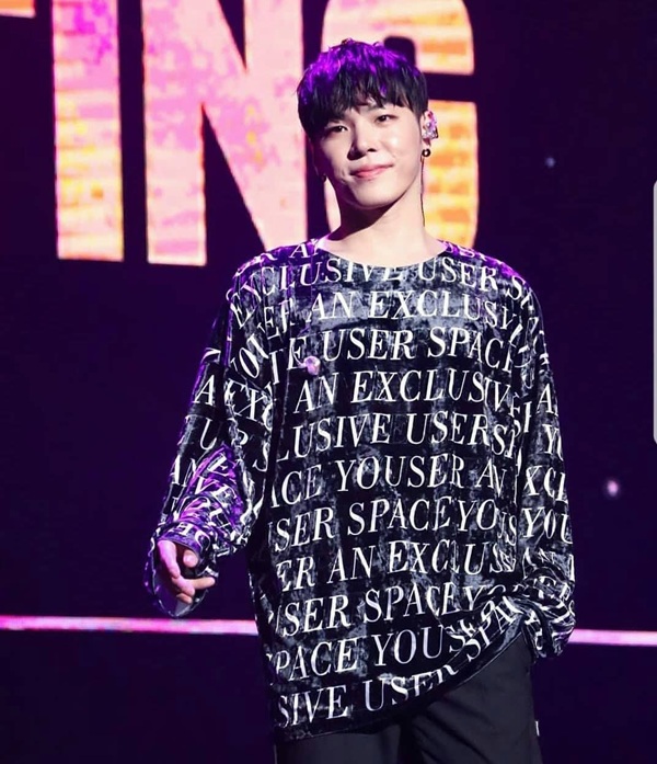 cantaretul wheesung pe scena cu microfonul in mana