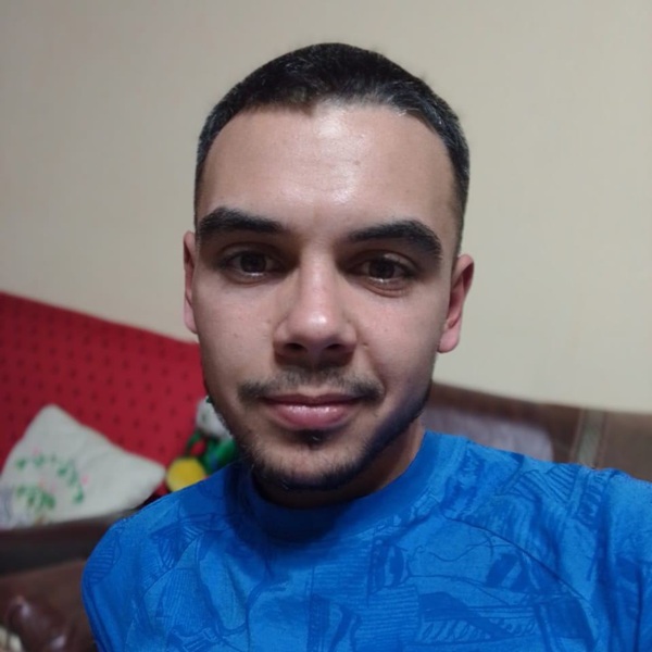 tanar imbracat in tricou albastru cu barba si mustata face un selfie