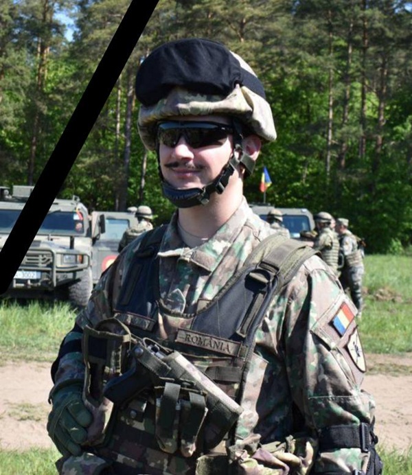 barbat imbracat in haine militare cu ochelari de soare la ochi