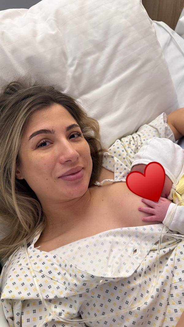 claudia puican imbracata in alb pe patul de spital cu bebelusul la piept