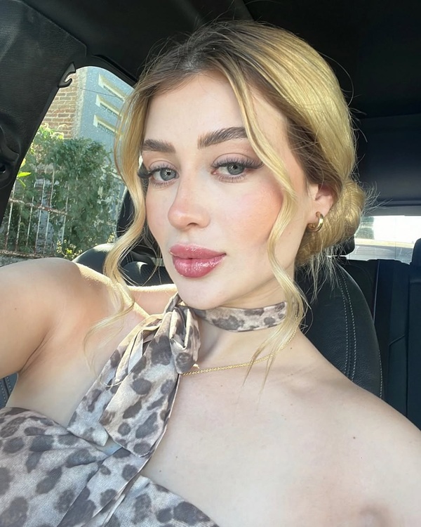 femeie blonda in rochie decoltata cu model in masina
