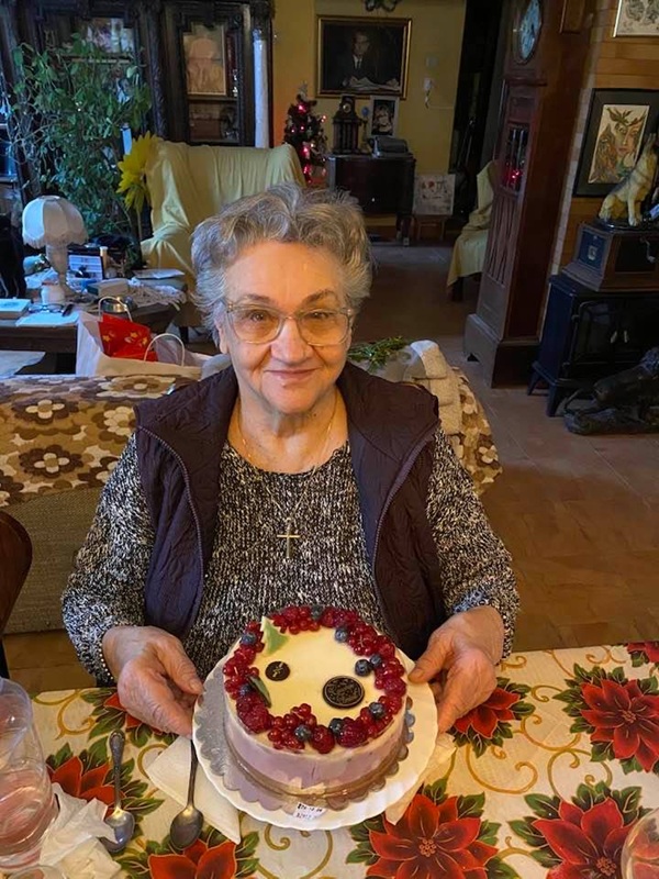 mama actritei carmen tanase cu un tort pe masa in fata ei