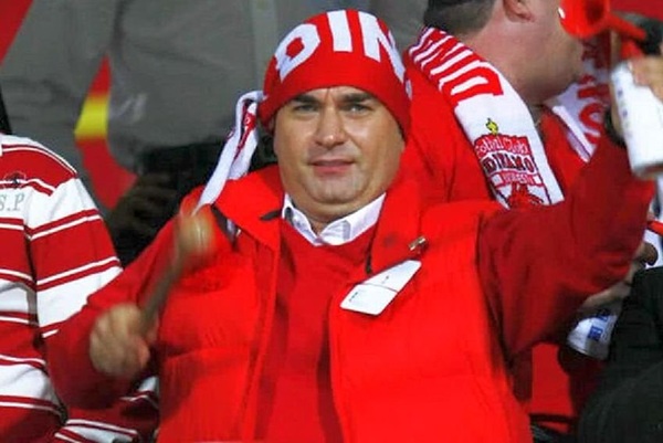 cristi borcea imbracat in rosu cu un fular rosu pe cap bate toba
