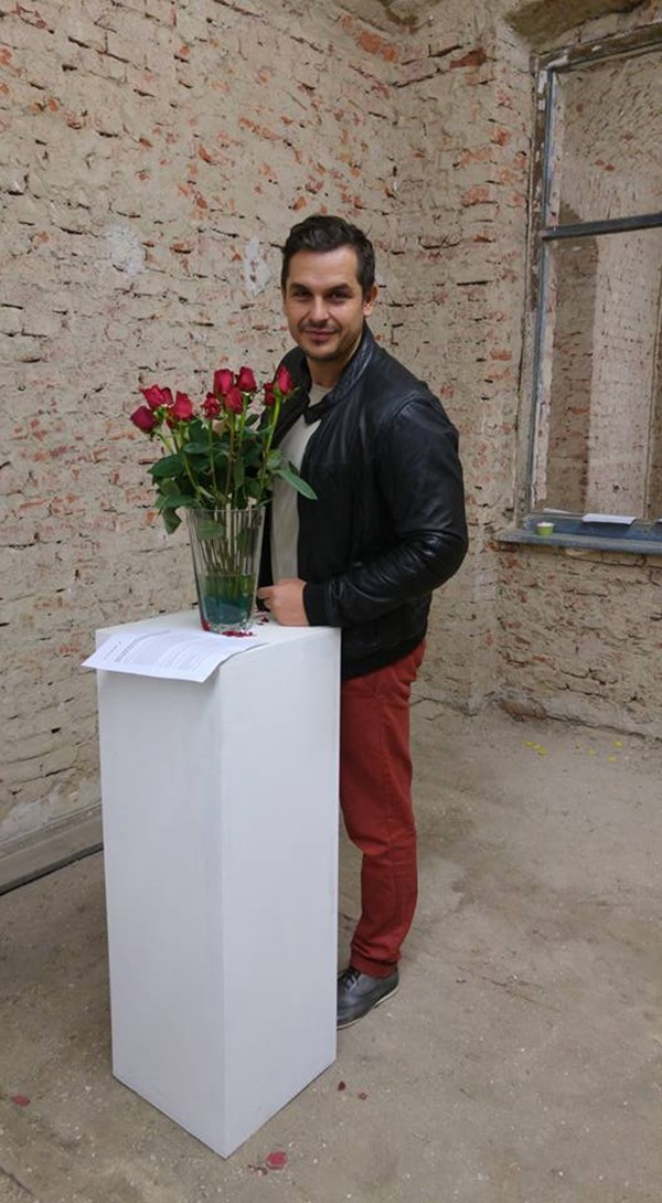 ciprian azoitei sta in picioare langa un buchet de trandafiri pe o masa