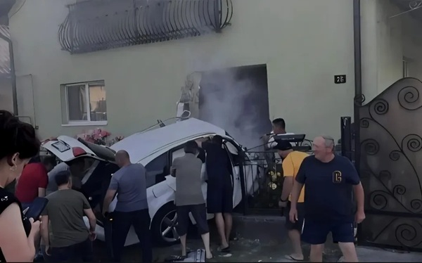 mai multi oameni stransi la fata locului unui accident cu o masina alba care a intrat intr-o casa