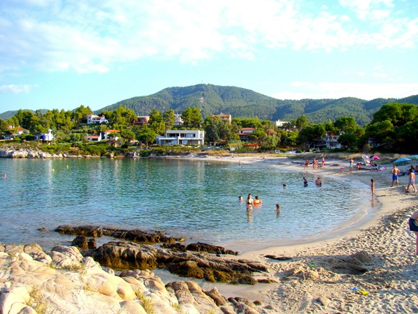 plaja din grecia cu turisti care fac baie in apa