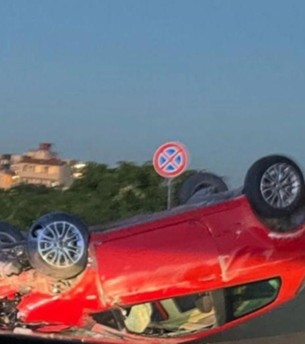 masina rosie rasturnata pe carosabil pe timp de noapte