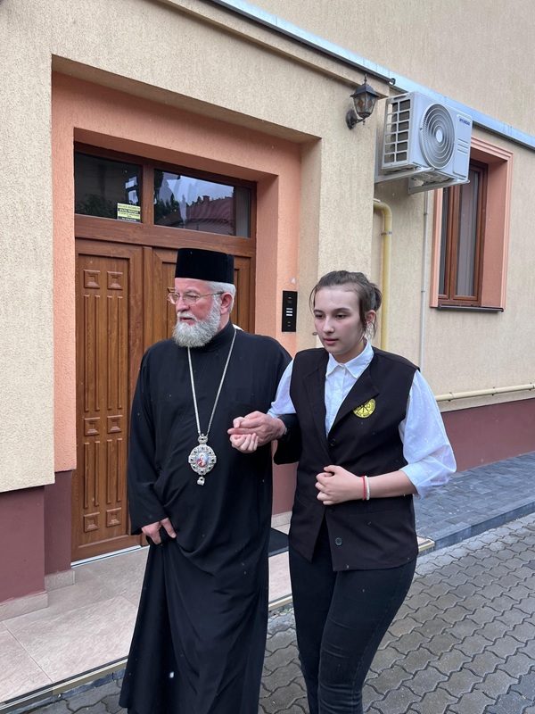 fata nevazatoare in uniforma langa un preot pe strada