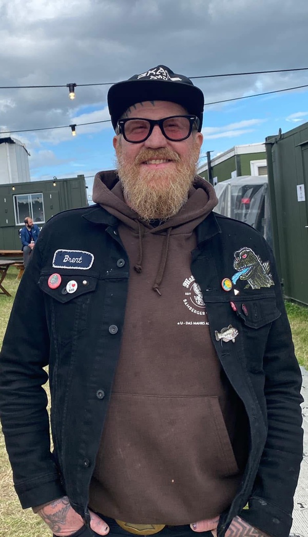 brent hinds in geaca de blugi cu insigne zambeste catre camera