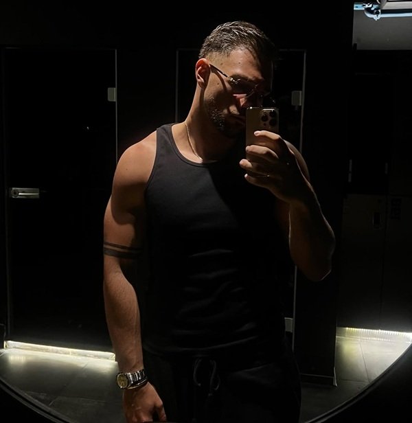 andrew barabancea in maiou negru si pantaloni de trening face selfie