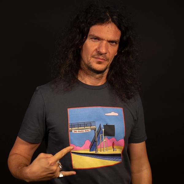 tudor chirila cu parul lung si cret face un semn cu mana