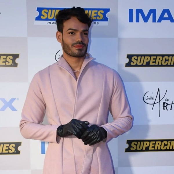emilio garcia imbracat intr-un trench roz cu manusi de piele in maini