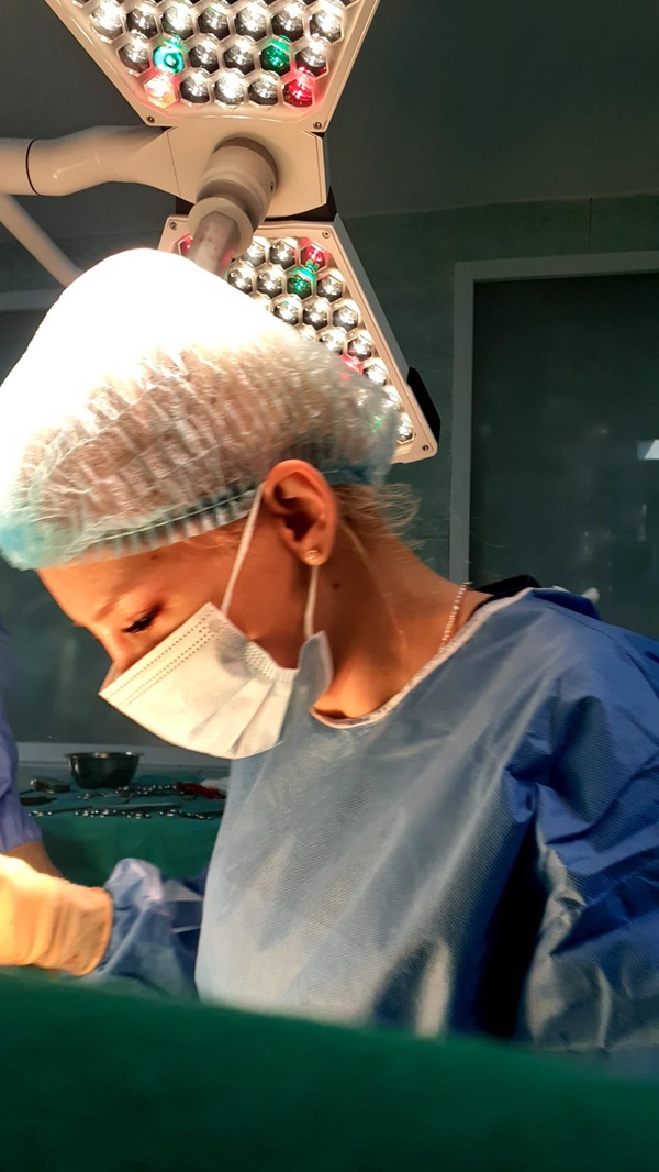 medic stefania szabo cu boneta pe cap si masca la gura in timpul unei operatii