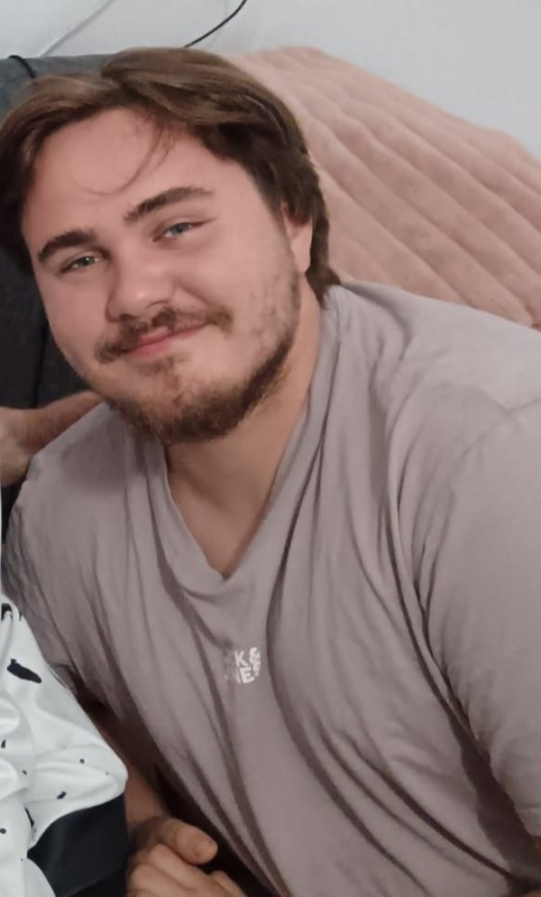 darius micluta cu parul lung imbracat intr-un tricou gri zambeste