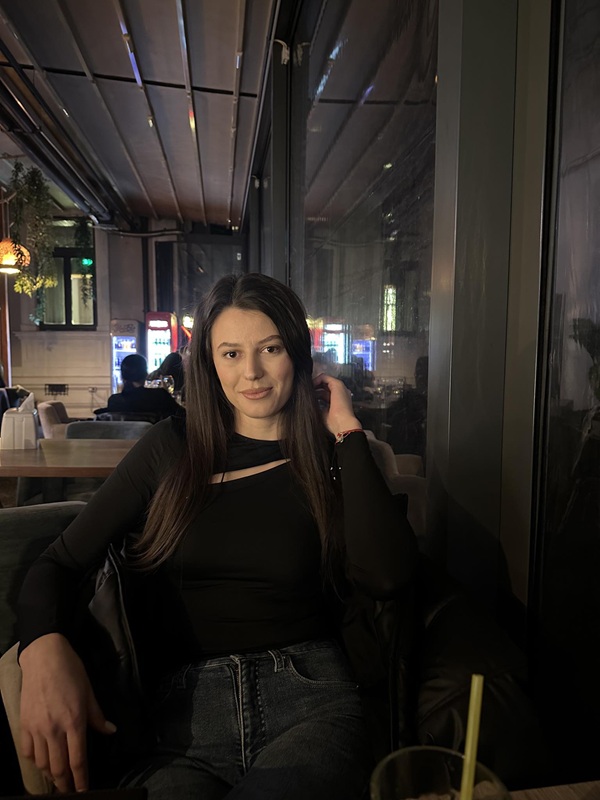 florina ologu imbracata in negru sta la o masa in oras