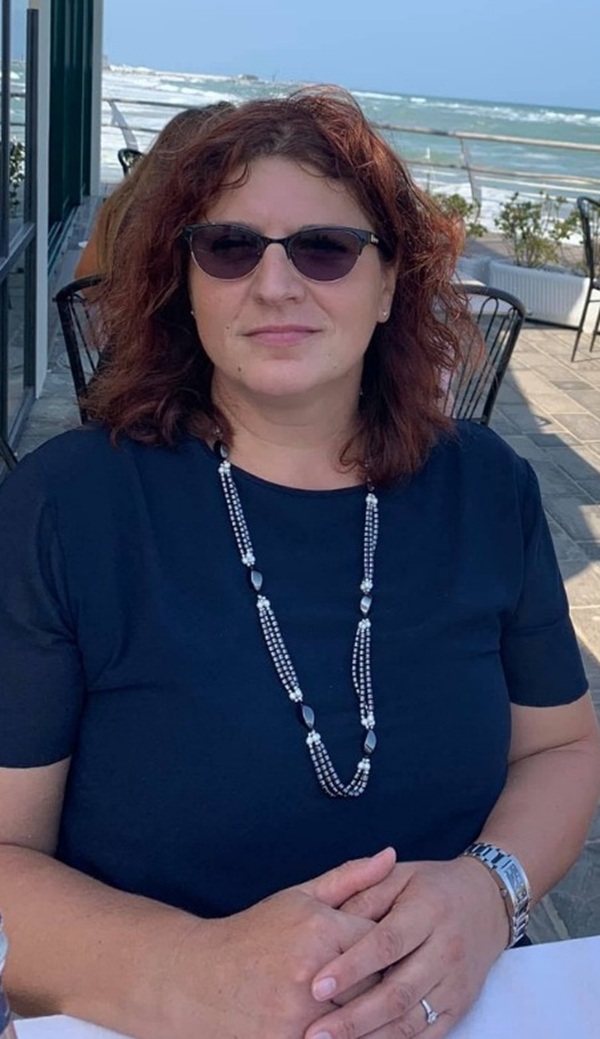 nina cristian femeie cu parul saten cu bucle si ochelari de soare la ochi