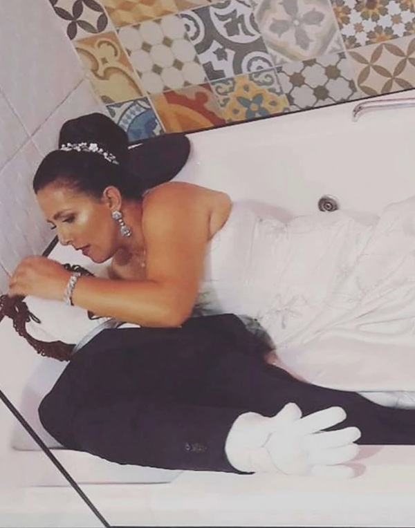 femeie in rochie de mireasa cu papusa de carpe