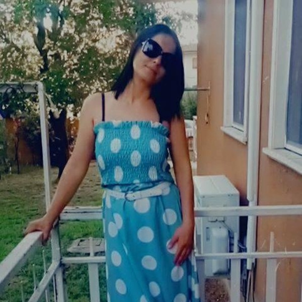 femeie cu parul negru lung imbracata in rochie albastra de vara cu buline albe