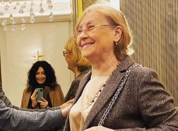 mihaela radulescu in fundal ii face o fotografie mamei ei in sacou mov care zambeste