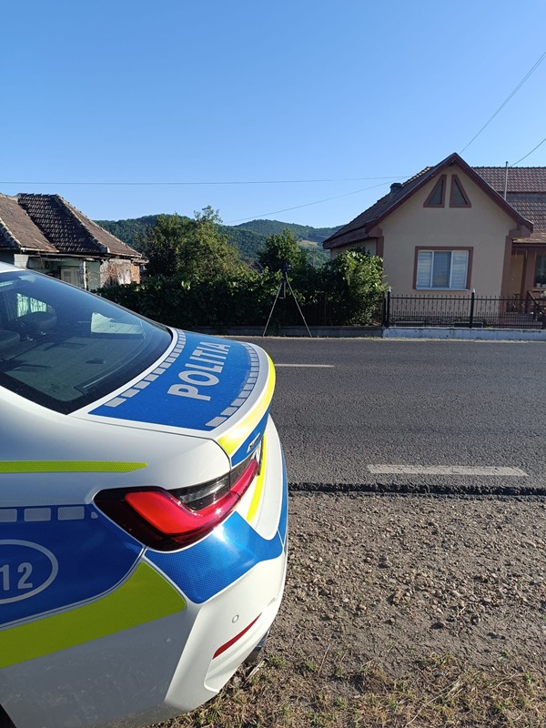 masina de politie trasa pe strada in fata unei case