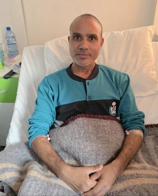 barbat in bluza albastra pe un pat de spital