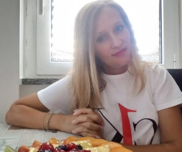 femeie blonda imbracata in tricou alb sta la masa