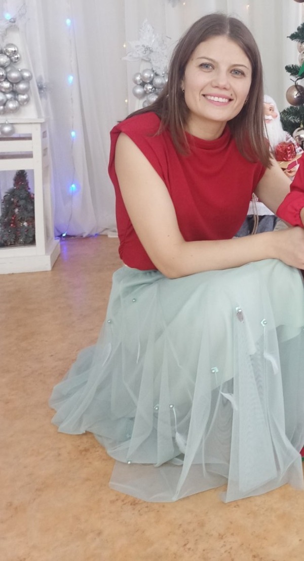 ludmila vartic imbracata in maleta rosie fara maneci si o fusta lunga albastra sta pe vine