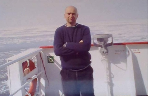 sorin tufan imbracat in blugi si pulover sta pe un vas pe mare cu mainile incrucisate