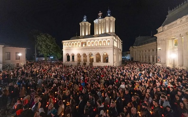 credinciosi stransi in curtea patriarhiei care iau lumina in noaptea de pasti