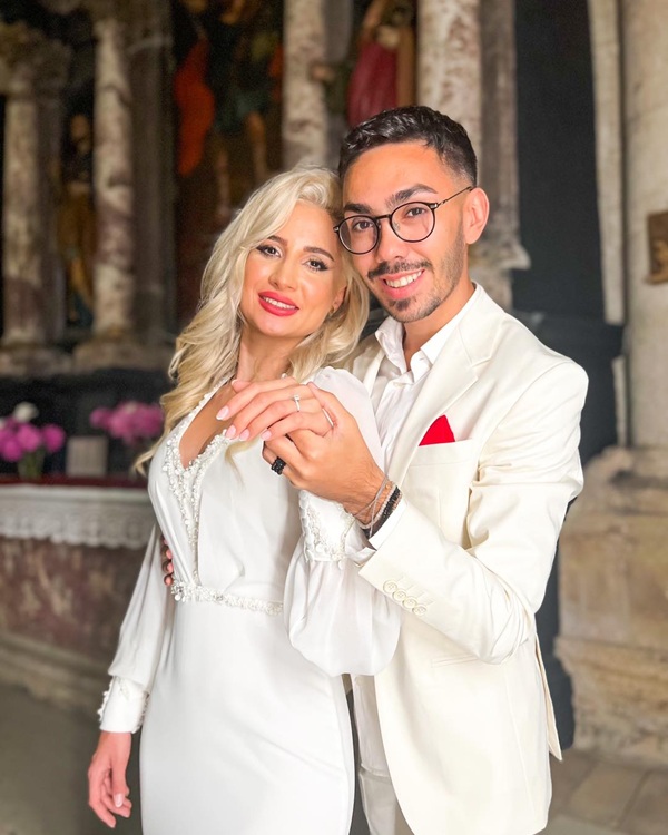 armin nicoara imbracat in costum alb o tine de mana pe sotia lui claudia puican imbracata tot in alb