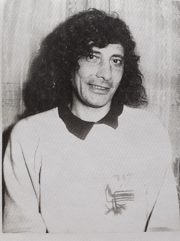 poza alb negru cu florian pittiș cu parul lung imbracat in tricou deschis la culoare