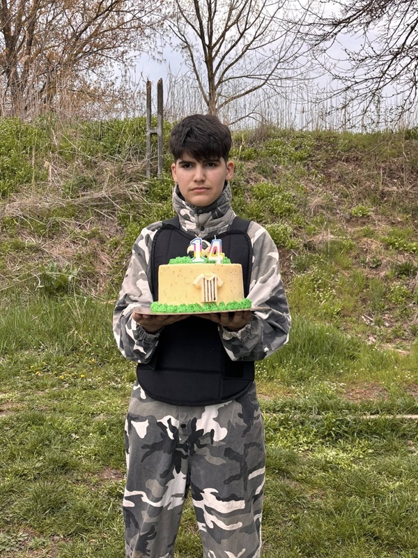 baiat imbracat in costum de camuflaj tine in mana un tort cu lumanari 14