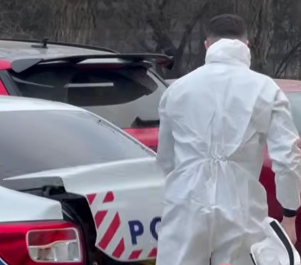 specialist de la criminalistica imbracat in alb langa o masina a politiei