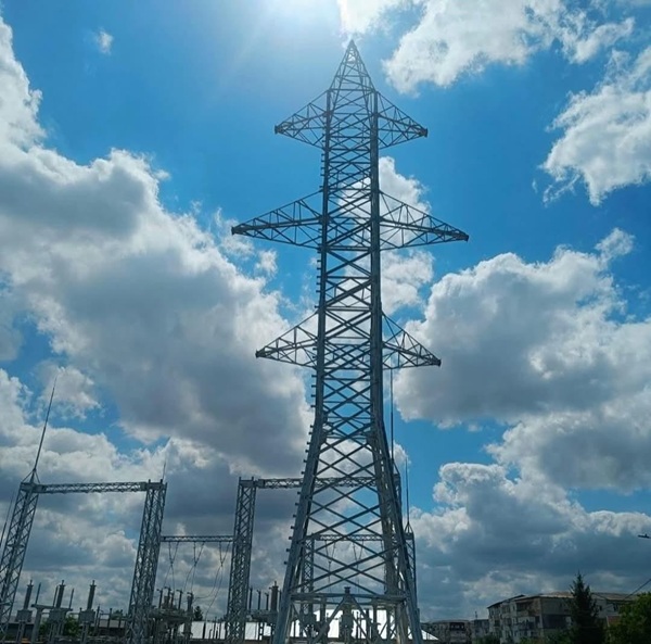 un releu de tensiune in camp cu cerul cu nori pe fundal