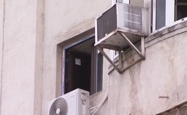 geamul de la o locuinta deschis in prim plan aparat de aer conditionat